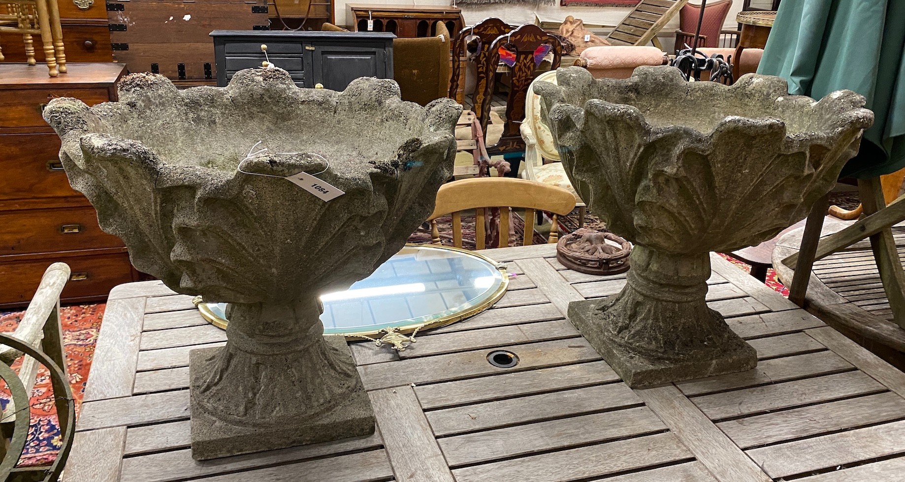 A pair reconstituted stone garden urns mounted with stylised leaves